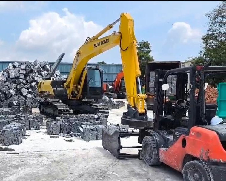 An excavator with a scrap magnet and a forklift handling scrap bales